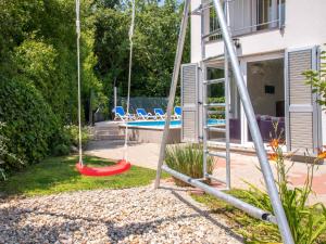 huśtawka przed domem z basenem w obiekcie Holiday Home Graziani by Interhome w mieście Kornić