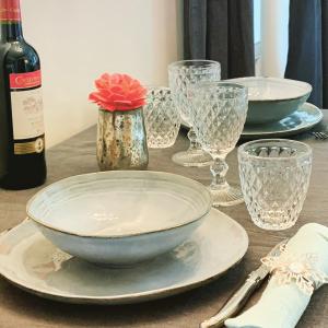 Beckerich的住宿－Isabelle's Rosegarden，一张带盘子和玻璃杯的桌子和一瓶葡萄酒