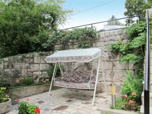 a chair under an umbrella in a garden at Apartment Vukelic-1 by Interhome in Novi Vinodolski