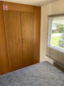 a bedroom with a bed and a window at Chalet Ibiza in de duinen van IJmuiden aan Zee in IJmuiden