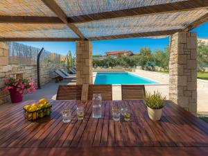 a wooden deck with a table and a swimming pool at Holiday Home Debora by Interhome in Vodnjan