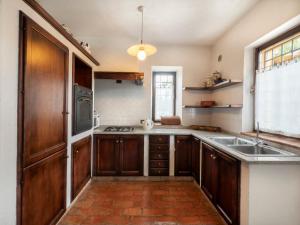 a kitchen with wooden cabinets and a sink at Holiday Home Domus Magna-1 by Interhome in Povoletto