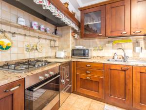 una cucina con armadi in legno e piano cottura. di Holiday Home Casa Tranquilla by Interhome a San Leonardo