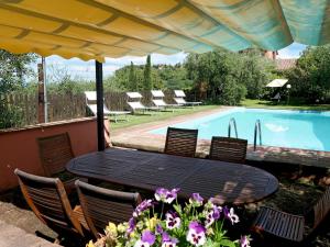 einen schwarzen Tisch und Stühle sowie einen Pool in der Unterkunft Holiday Home Casale L'Uliveta by Interhome in Canneto