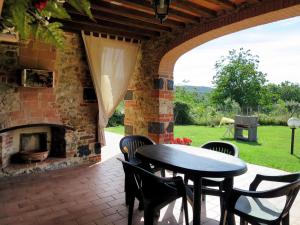 un patio con mesa, sillas y chimenea en Apartment Agriletizia by Interhome en La Pesta