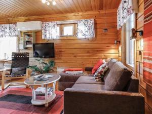 a living room with a couch and a tv and a table at Holiday Home Sallanrinne b by Interhome in Salla