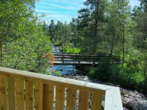 a wooden bridge over a stream with a bridge over a river at Chalet Sandrabu - SOW056 by Interhome in Øyuvstad