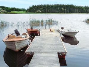three boats are docked at a dock on a lake at Holiday Home Järnemåla Margaretetorp by Interhome in Valdemarsvik