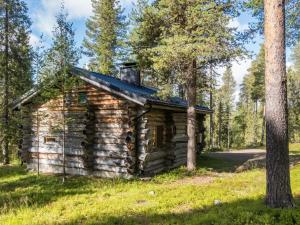 an old log cabin in the woods with a tree at Holiday Home Ukkohermanni by Interhome in Luosto