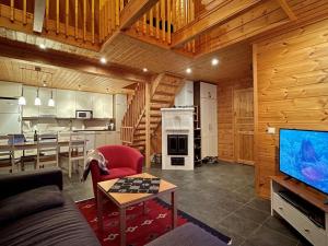 een woonkamer met een bank en een tv en een keuken bij Holiday Home Ylläsriekko - itätupa by Interhome in Ylläsjärvi