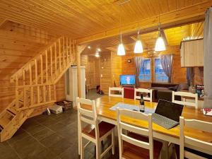 een keuken en eetkamer met een tafel en een laptop bij Holiday Home Ylläsriekko - itätupa by Interhome in Ylläsjärvi