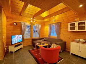 a living room with a couch and a tv at Holiday Home Ylläsriekko - itätupa by Interhome in Ylläsjärvi