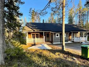 een klein huis met een veranda in het bos bij Holiday Home Ylläsriekko - itätupa by Interhome in Ylläsjärvi