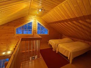 a attic room with two beds and two windows at Holiday Home Ylläsriekko - itätupa by Interhome in Ylläsjärvi +8 photos