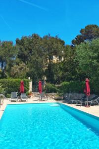 - une piscine avec des chaises longues et des parasols dans l'établissement Apartment Villa Vivendi - VEN109 by Interhome, à Vence