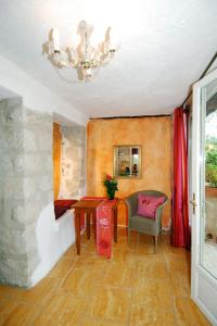 Cette chambre comprend une table, une chaise et un lustre. dans l'établissement Apartment Villa Vivendi - VEN109 by Interhome, à Vence