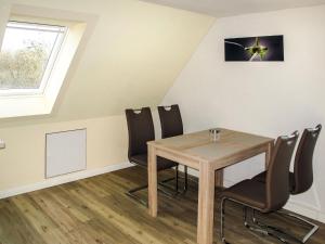 - une salle à manger avec une table et des chaises en bois dans l'établissement Apartment zum Katzengrund II by Interhome, à Hinrichshagen