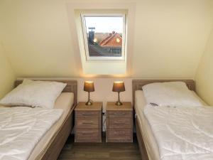 two twin beds in a room with a window at Apartment zum Katzengrund II by Interhome in Hinrichshagen