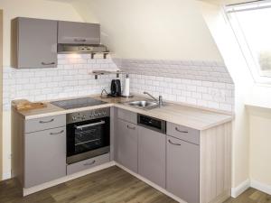 a small kitchen with a sink and a stove at Apartment zum Katzengrund II by Interhome in Hinrichshagen