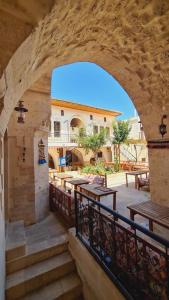 an archway leading to a patio with tables and benches at nahrin hote & art in Sanlıurfa