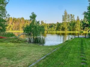 un parc avec un lac et une pelouse dans l'établissement Holiday Home Majavanpesä by Interhome, à Virtasaari