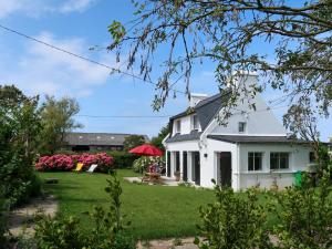 ein weißes Haus mit einem Hof mit rosa Blumen in der Unterkunft Holiday Home Ty va Zud by Interhome in Lampaul-Ploudalmézeau