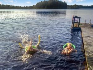 two children playing in the water on a lake at Holiday Home Palkinniemi by Interhome in Putikko