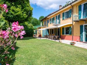 Blick auf den Hof eines Hauses mit rosa Blumen in der Unterkunft Apartment Cascina Virginia-5 by Interhome in Vigliano d'Asti