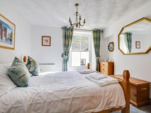 a bedroom with a large bed and a window at Holiday Home Violet by Interhome in Looe