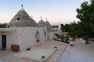 un bâtiment avec un toit pyramidal et une cour dans l'établissement Trullo Il cantagallo, à Locorotondo