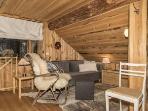 un salon avec un canapé et un lit dans une cabine dans l'établissement Holiday Home Tunturitorppa by Interhome, à Äkäslompolo