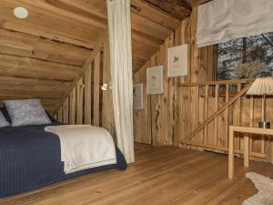 une chambre avec un lit dans une cabane en bois dans l'établissement Holiday Home Tunturitorppa by Interhome, à Äkäslompolo