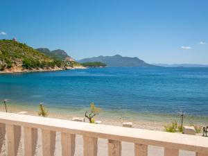 a view of a beach with a white fence at Apartment Jelka-2 by Interhome in Trstenik