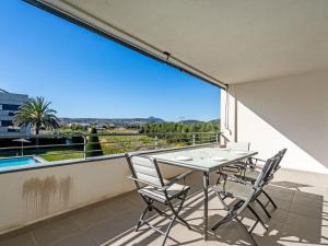 a balcony with a table and chairs and a large window at Apartment Isleta Marina-3 by Interhome in Jávea