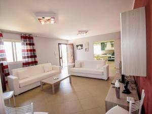 a living room with two white couches and a table at Villa Orange by Interhome in Solarino