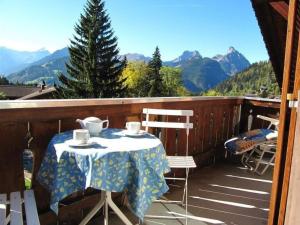 a table and chairs on a balcony with mountains at Apartment Monique Nr- 1 by Interhome in Gstaad