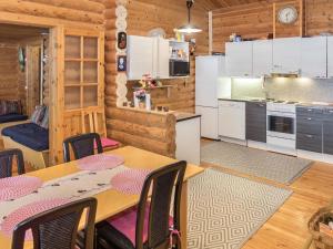 eine Küche und ein Esszimmer mit Tisch und Stühlen in der Unterkunft Holiday Home Imponlampi by Interhome in Rukajärvi + 16 Fotos