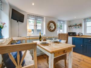 a kitchen with a table and chairs and a television at Holiday Home Pendeen Hayloft by Interhome in Saint Stephen