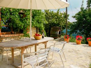 a wooden table with chairs and an umbrella at Apartment Gallo - MZO103 by Interhome in Belvedere Langhe