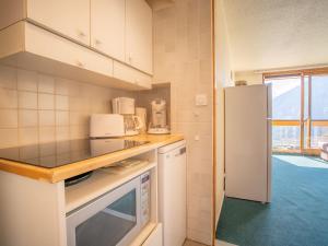 a kitchen with a counter top and a refrigerator at Apartment Soyouz Vanguard-87 by Interhome in Le Corbier