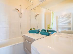 a white bathroom with a sink and a mirror at Apartment Soyouz Vanguard-87 by Interhome in Le Corbier