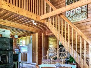 a wooden staircase in a kitchen with two chairs at Holiday Home Niittyranta by Interhome in Kukko