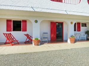 Podere DottrinaにあるApartment Villa Sassi by Interhomeの椅子2脚と赤い扉付きの家