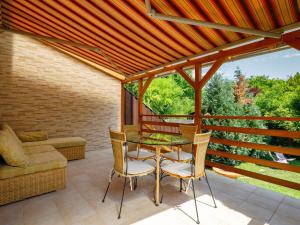 taras ze stołem, krzesłami i kanapą w obiekcie Holiday Home Violetta Grande by Interhome w mieście Balatonkenese
