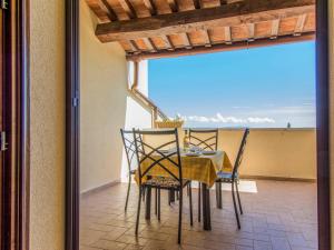 uma mesa de jantar e cadeiras numa varanda em Apartment Poggio di Nocola-1 by Interhome em Riparbella