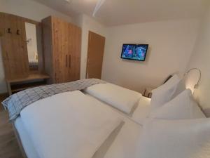 a bedroom with a white bed and a tv on the wall at Apart Lisa in Mayrhofen
