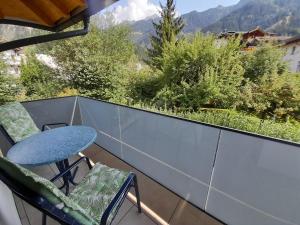 a balcony with a table and chairs and mountains at Apart Lisa in Mayrhofen +11 photos