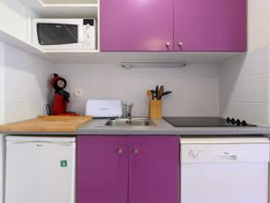 une cuisine avec des armoires violettes et un évier dans l'établissement Apartment Bâtiment A-20 by Interhome, au Corbier