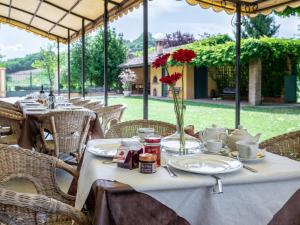 une table avec des assiettes, des tasses et des fleurs dans l'établissement Holiday Home Cascina Virginia-6 by Interhome, à Vigliano d'Asti