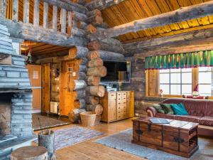 een woonkamer met een bank en een open haard in een blokhut bij Holiday Home Terakka by Interhome in Levi